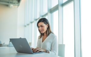 Autónoma trabajando con portátil en un espacio luminoso, imagen del Seguro de Salud para Autónomos Caser