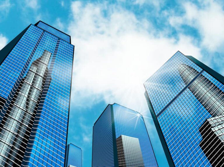 Rascacielos corporativos iluminados por el sol, representando las grandes empresas que pueden contratar seguros de salud Caser.